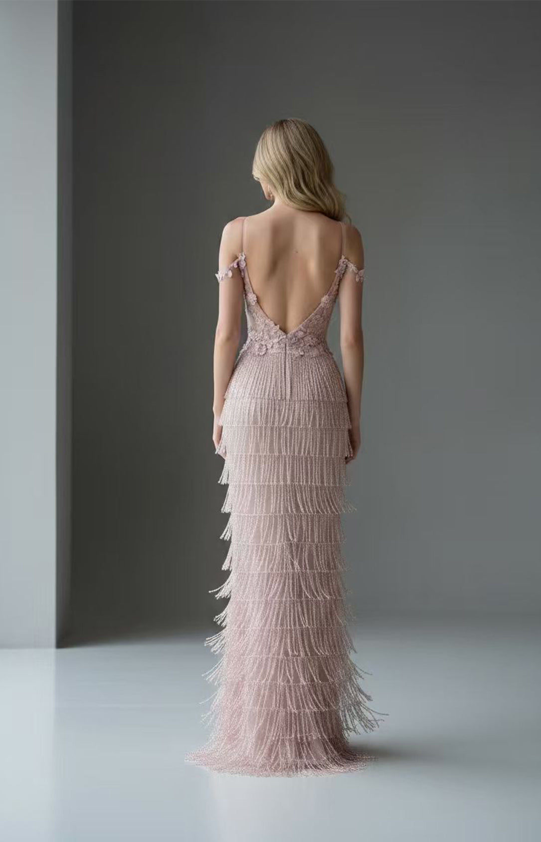Back view of blush pink beaded fringe prom dress featuring open V-back and floral straps by Xalpheor