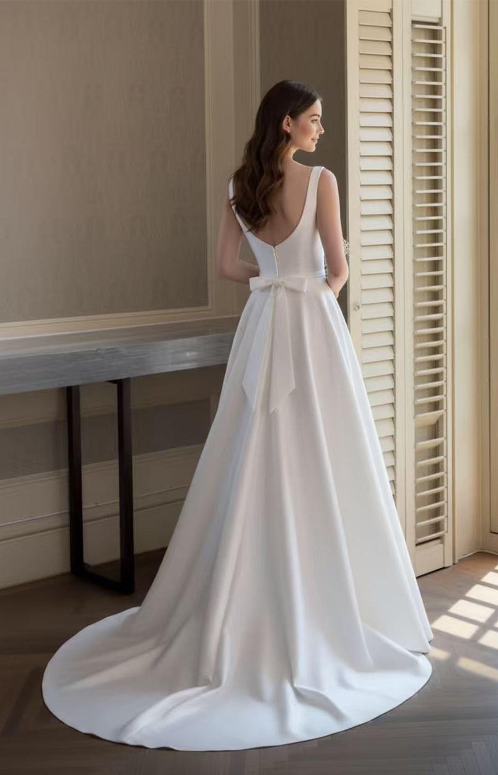Classic white A-line bridal gown back view featuring a V-back, bow detail, and sweeping train - XALPHEOR