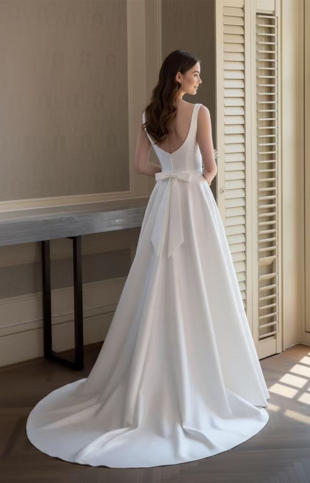 Classic white A-line bridal gown back view featuring a V-back, bow detail, and sweeping train - XALPHEOR