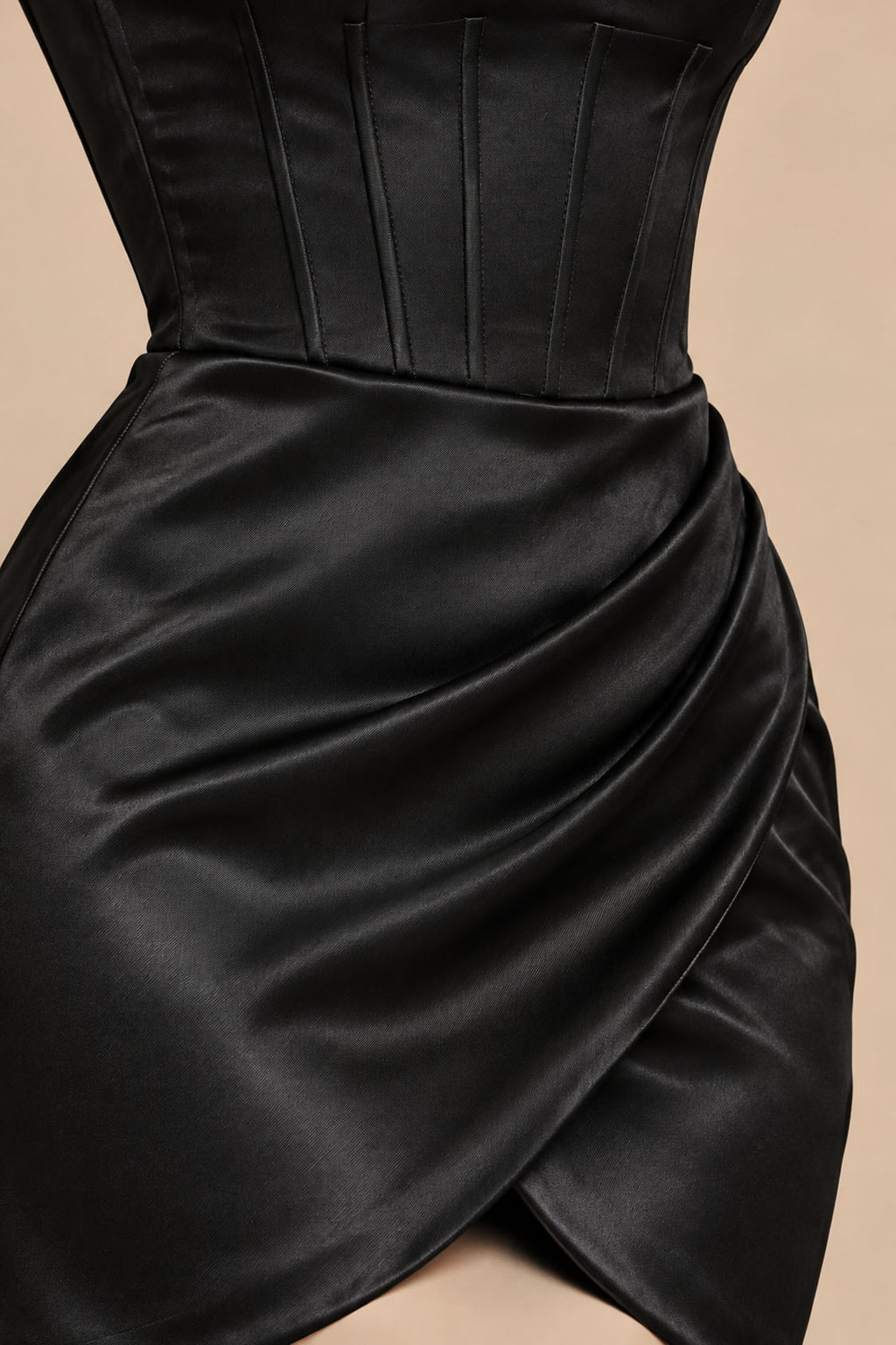 Close-up of black satin corset boning and draped tulip wrap skirt on a homecoming mini dress