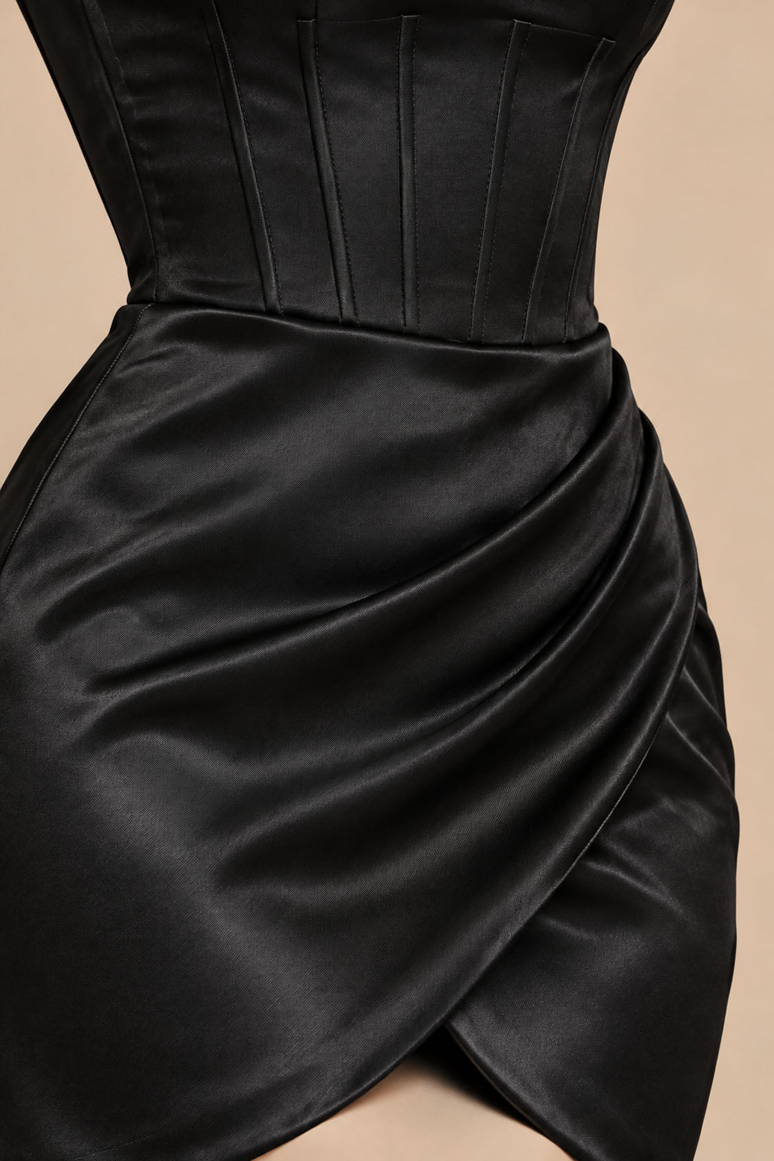 Close-up of black satin corset boning and draped tulip wrap skirt on a homecoming mini dress